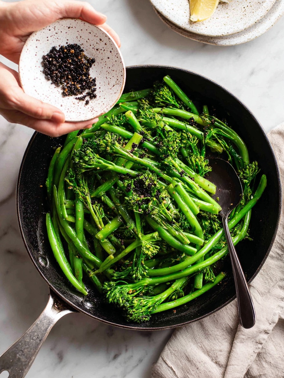A close-up photo shows a stainless steel pan filled with bright green broccolini and green beans, glistening as they cook. Above the pan, a woman's hand is holding a white speckled bowl, pouring small dark red lentils into the pan. Inside the pan, a black spoon with a smooth handle is resting among the vegetables. The scene is set on a white marbled surface, making the colors of the vegetables and lentils stand out clearly. photo taken with an iphone --ar 2:3 --v 7