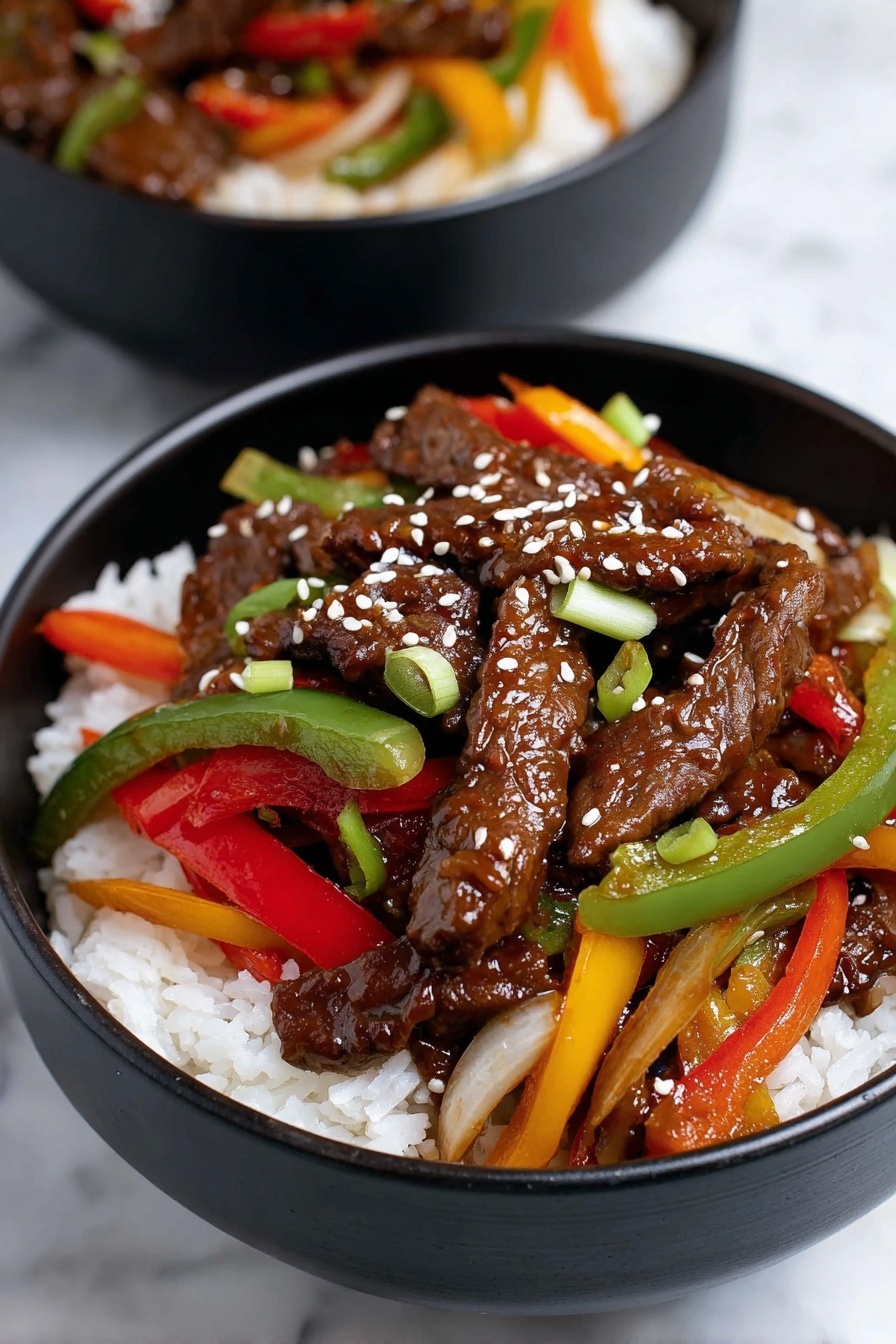 A black bowl filled with white steamed rice as the bottom layer. On top, there is a colorful mix of dark brown stir-fried beef strips, bright red and green bell pepper slices, orange carrot strips, light green scallions, and translucent cooked onions. The beef and vegetables are coated in a shiny sauce and sprinkled with white sesame seeds, adding texture. In the background, there is another bowl with the same dish. The surface beneath the bowls is a white marbled texture. Photo taken with an iphone --ar 2:3 --v 7