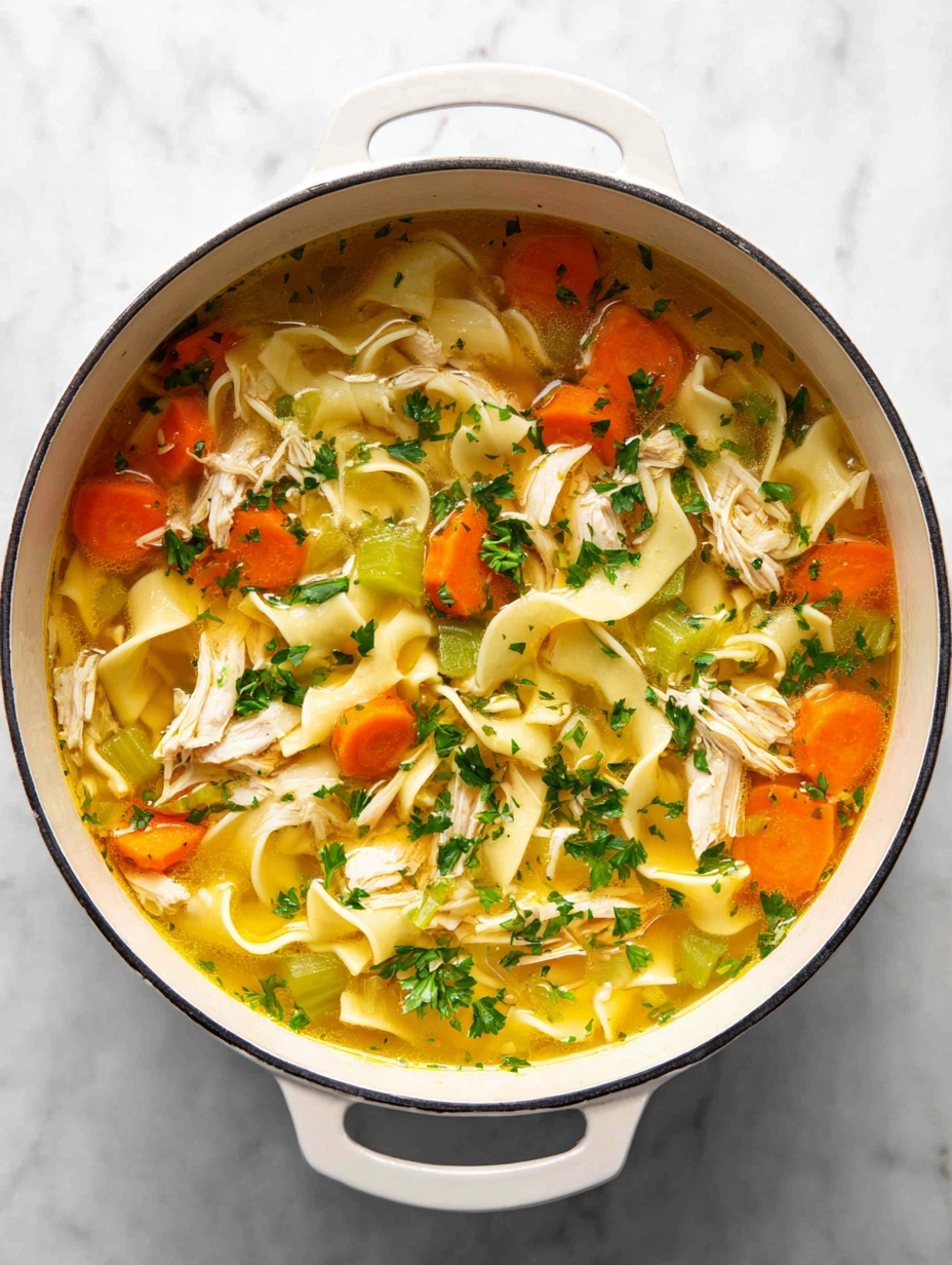 A close-up top view of a bowl of chicken noodle soup with three main layers: the clear golden broth fills the bowl, mixed with thin sliced orange carrot rounds scattered throughout, chopped green celery pieces, and shredded white chicken meat. Flat, wide egg noodles with a pale yellow color float in the soup, some layered on top of the broth and vegetables. Small green parsley leaves are sprinkled over the soup adding fresh texture. The soup is served in a white bowl placed on a white marbled surface. Photo taken with an iphone --ar 2:3 --v 7