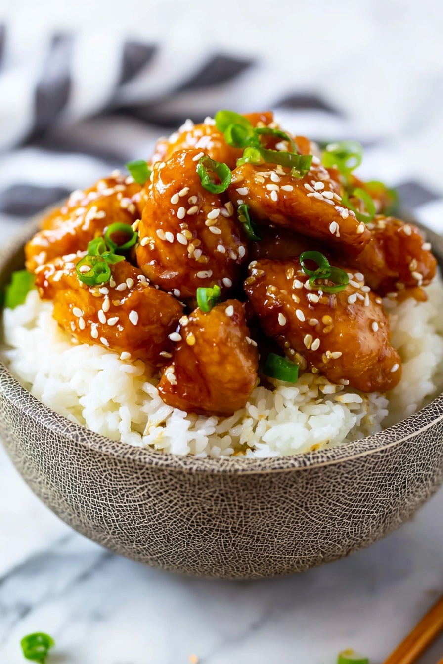 A bowl filled with a base layer of fluffy white rice. On top of the rice, there is a thick layer of glossy, brown glazed chicken pieces that look tender and juicy, covered with a shiny sauce. Scattered evenly on the chicken are small white sesame seeds and chopped green onions adding color and texture. The dish is served in a white bowl with a crackled pattern, placed on a white marbled surface. photo taken with an iphone --ar 2:3 --v 7